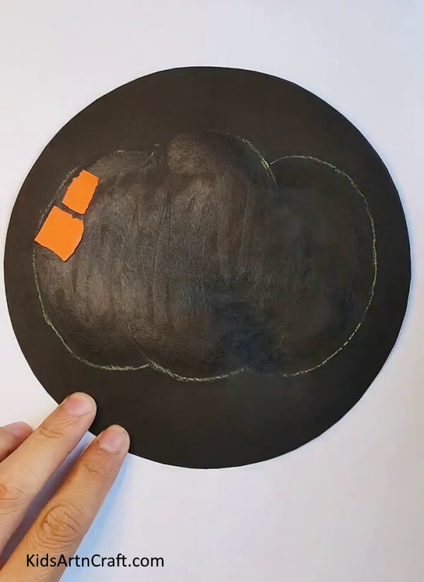 Starting a Sticking the Bits of Paper Inside the Pumpkin Outline - Learn how to construct a paper pumpkin