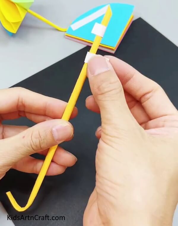 Applying Tape Over The Stick - Making A Paper Umbrella That Is Easy For Kids To Do