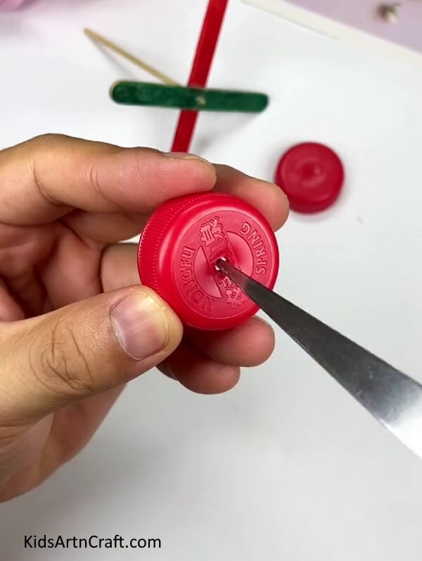 Making A Hole In The Bottle Cap - Putting Together a Pinwheel with Popsicle Sticks and a Bottle Cap