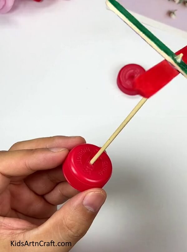 Inserting The Toothpick Into Bottle Cap Hole - Develop a Pinwheel with Popsicle Sticks and a Bottle Cap