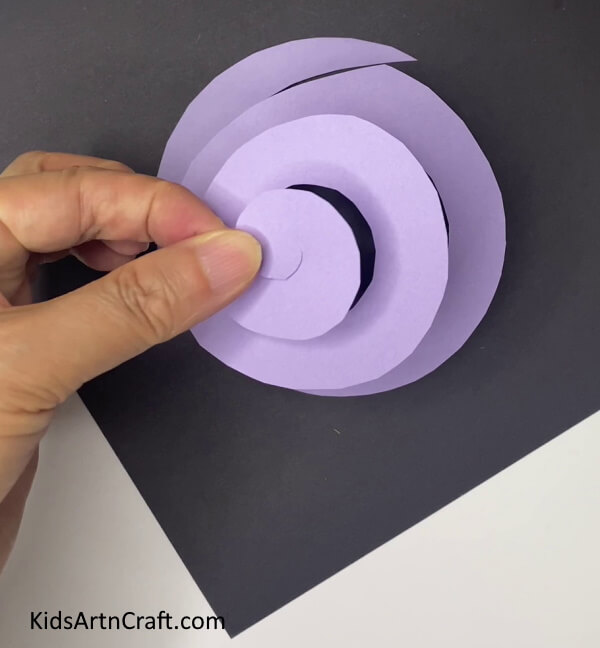 Completing The Spiral Steps to Form a Violet Paper Bloom With Leaves
