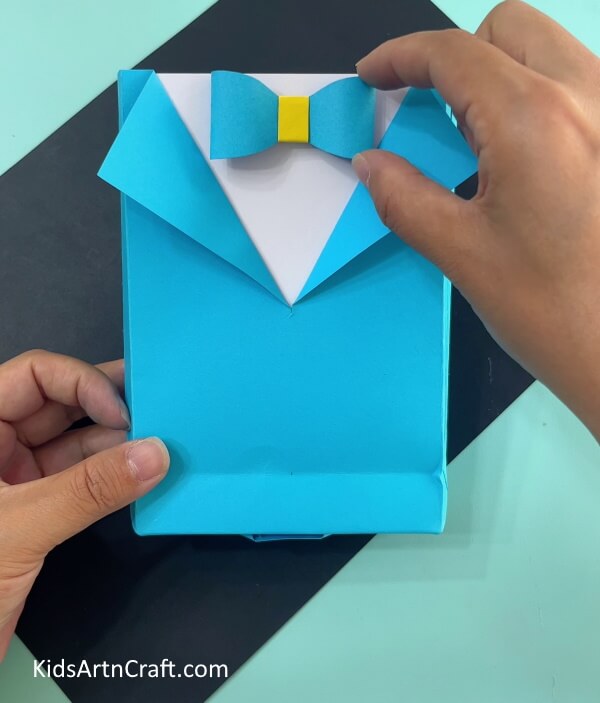 Pasting The Bow Producing an Origami Paper Bag with a Shirt and Bow at Home 