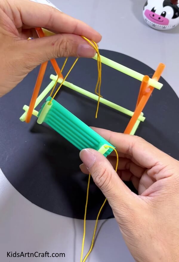 Tieing The Theard Over The Straw - A Fun Straw Swing Crafting Tutorial For Kids To Assemble