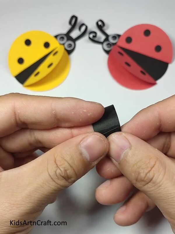 Joining The Ends Of The Strip Together-A user-friendly tutorial to help kids make a ladybug paper ring. 