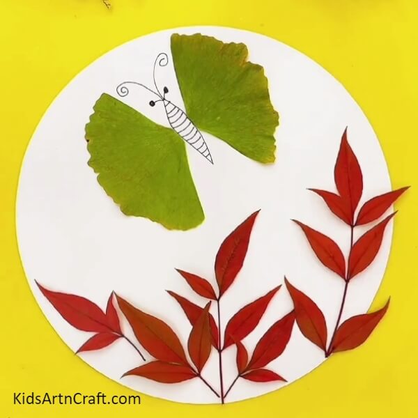 Stick more leaves in the lower portion of the white sheet- A simple leaf garden and butterfly craft for beginners