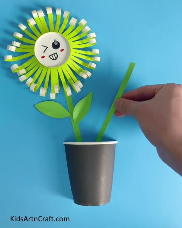 Pasting One More Green Stem-Demonstrate to your children the method of making a Paper Cup Flower