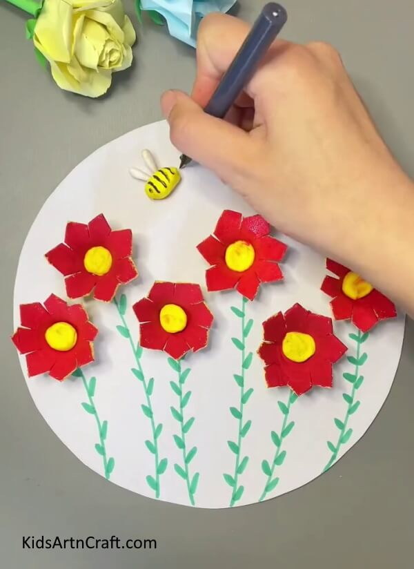 Making details of the bee with black Marker- Bees Craft Tutorial will show you the steps to arrange Egg Carton Blooms