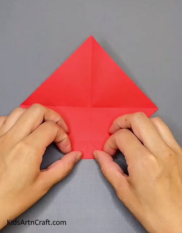 Fold the Red Craft Paper From Bottom- Get yourself familiarized with the steps of producing an Origami Paper Ninja Star through this craft tutorial. 