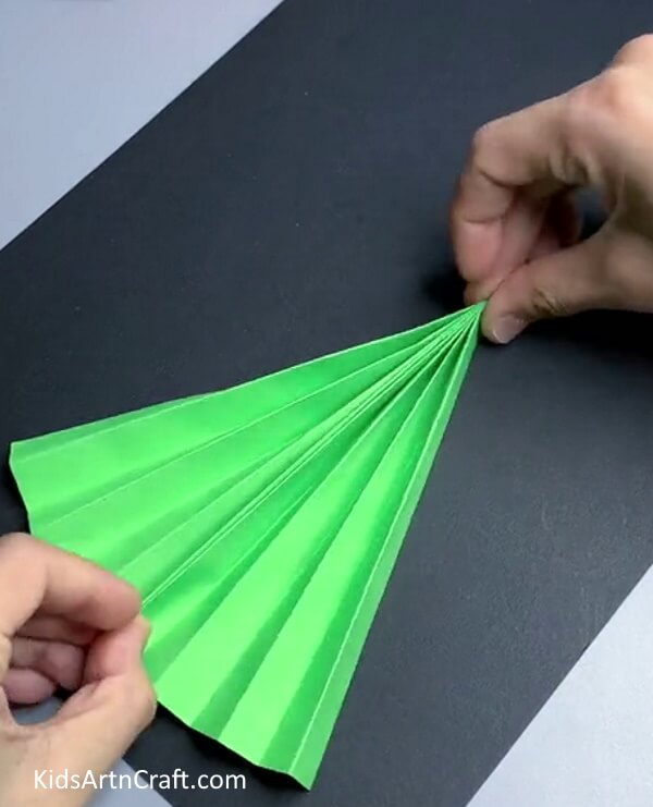 Bring The Folds Of One Side Together for making Christmas Tree Craft for kids