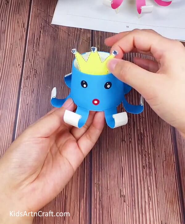 Make the Eyes, Mouth, and Crown-Cultivate the skill to fashion a Paper Cup Octopus Craft for Toddlers