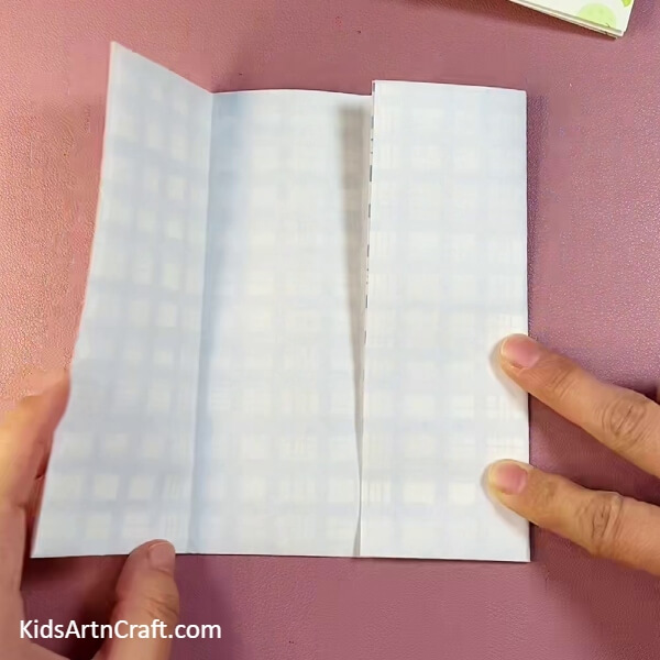 Folding right side of the craft paper into the center- Assemble a Handy Origami Container For Little Ones