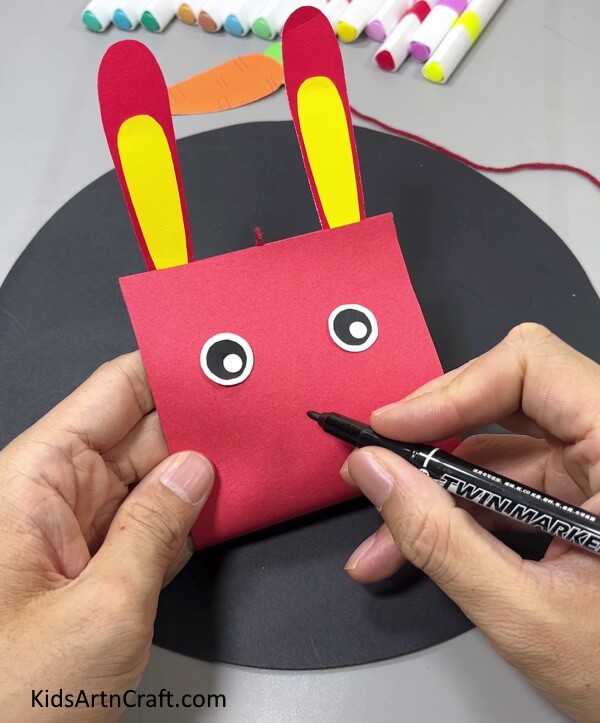 Drawing Mouth Of The Bunny- Making this bunny and carrot decoration with paper is effortless.