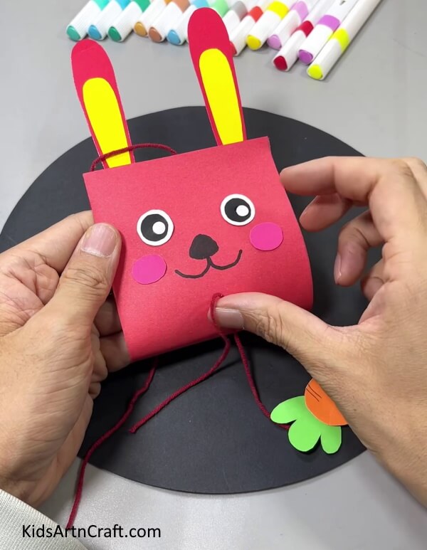 Pasting The Carrot's Thread On The Bunny- Craft a Hanging Bunny and Carrot Decoration Using Paper