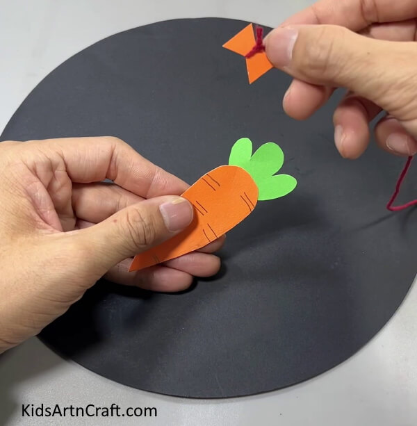 Cutting An Hourglass Shape From Orange Paper - This is a straightforward and simple paper-crafted bunny and carrot decoration.