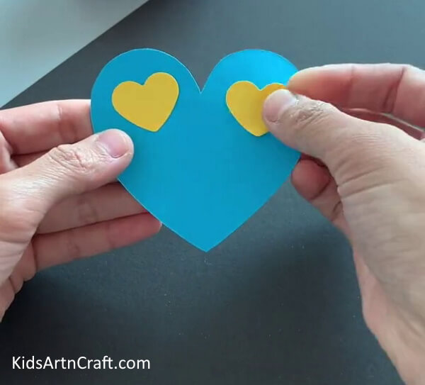 Pasting Yellow Hearts - Children can have fun making simple paper butterflies.
