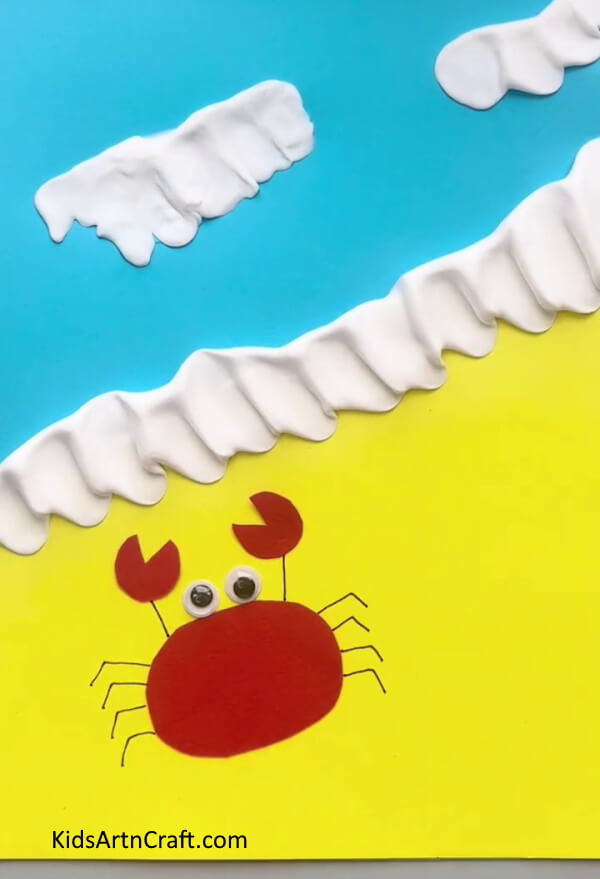 Adding Googly Eyes - Building paper crabs on the beach for kids 