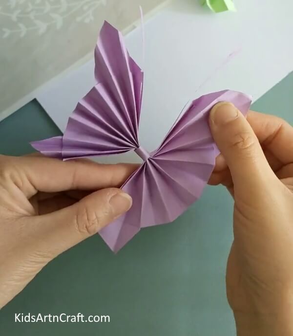 Pasting The Antennas- Constructing a paper origami butterfly - a how-to guide for children.