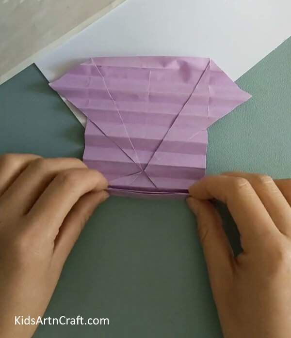 Making Compressed Folds To The Sheet- A step-by-step tutorial for crafting a Paper Origami Butterfly for children