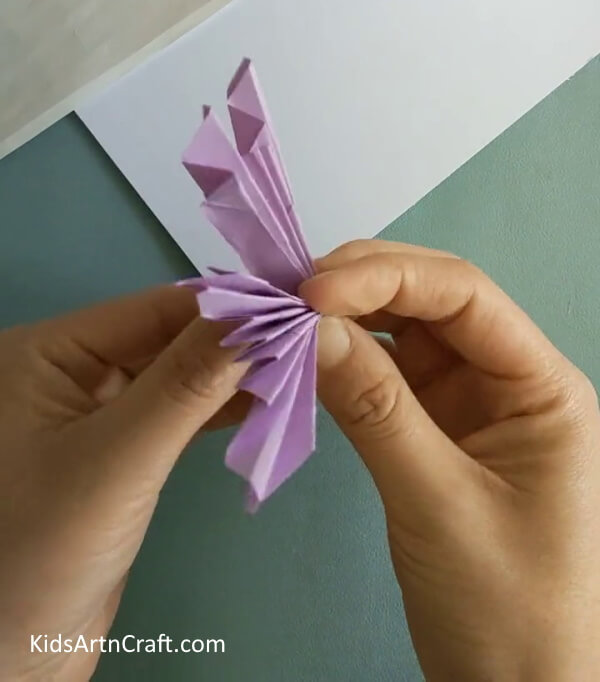 Applying Pressure To The Middle Of The Compression- A guide for crafting a Paper Origami Butterfly - for kids