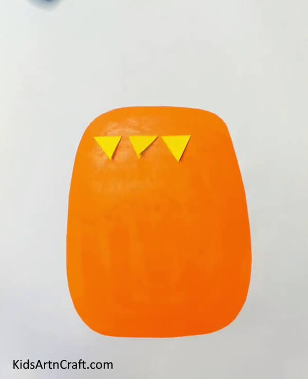 Stick The Triangles On An Orange Craft Paper for looking good Pineapple Paper- A kid-friendly guide to crafting with Pineapple Paper 