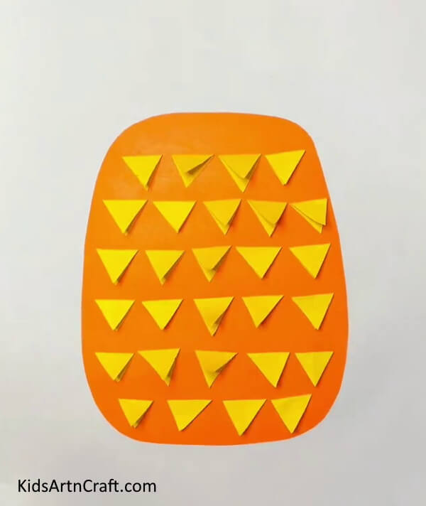Keep Sticking The Triangles Till The End On Orange Craft Paper easy tutorial for kids- A tutorial on constructing Pineapple Paper Projects for young ones 