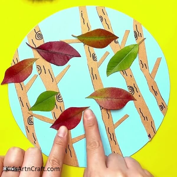 Completing Pasting Leaves- Avian melodies guiding youngsters in leaf craft. 