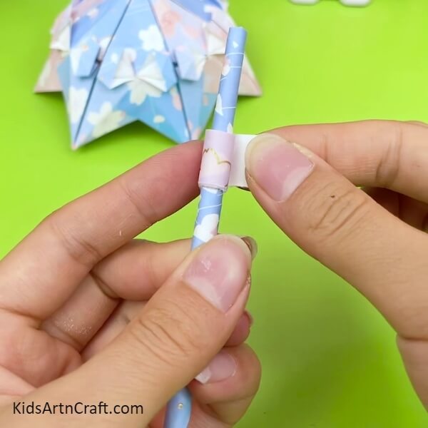 Stick Another Printed Paper On The Umbrella Stick with your hand to look Creative Craft - A Step-By-Step Tutorial For Kids To Create An Origami Umbrella 