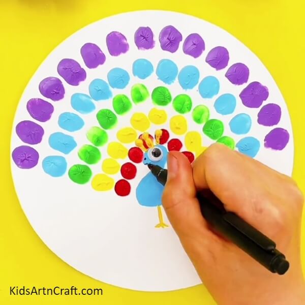 Design the features of the peacock using a marker- Spectacular Peacock Finger Painting For Little Ones