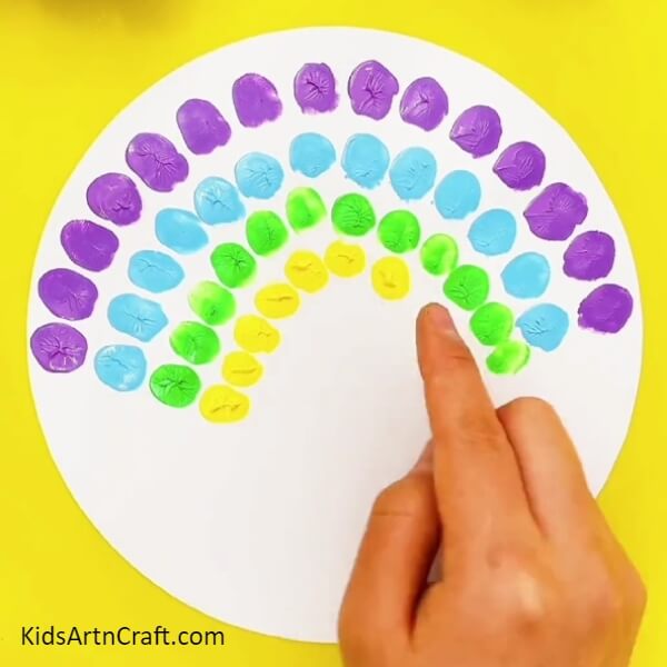 Dip your index finger in yellow paint and make similar impressions with your finger- Charming Peacock Fingerprint Painting Concept For Children