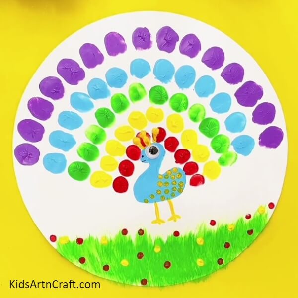 Design flowers on the grasses using yellow and red paint- Fun Fingerprint Artwork Of A Peacock For Kids