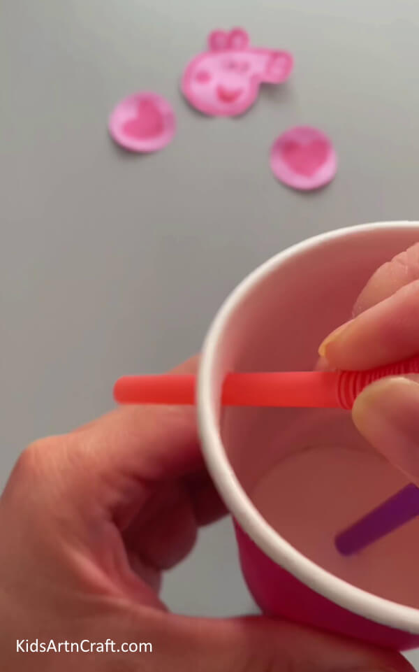 Inserting the Other Two Straws- Learn how to create a Peppa Pig hanging craft from used paper cups with this tutorial for kids. 