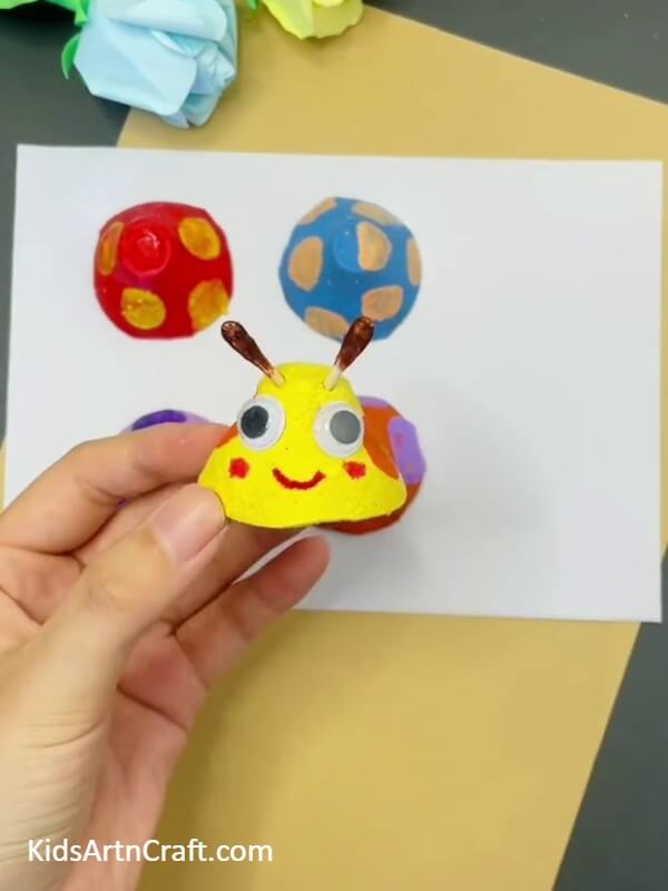 Putting The Antennae On The Caterpillar- Craft a Stylish Caterpillar Out of a Reused Egg Carton with This Tutorial for Kids 