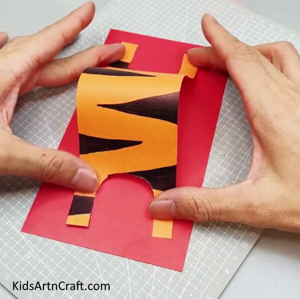 Pasting The Sheet Over Red Paper - Follow along to create a paper tiger, step-by-step