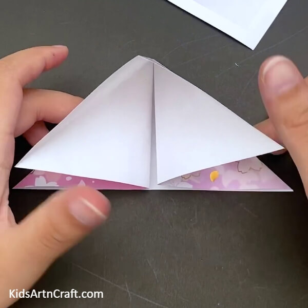 Folding The Sheet On The Lines On The Folds Made Earlier to Make a Paper Boat From Paper- Crafting a Paper Origami Boat with kids - step by step instructions 