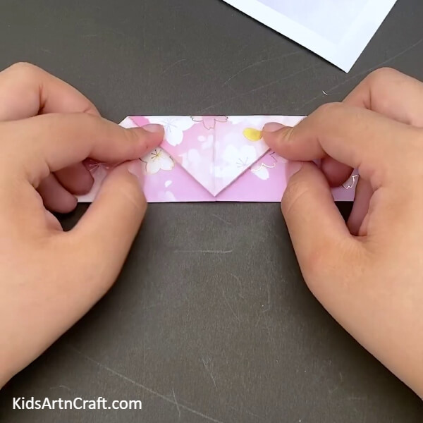 Making A Small Fold At The Top Of This Triangle Step-by-Step Instructions For Crafting a Paper Boat- A comprehensive instruction on how to construct a Paper Origami Boat for children 