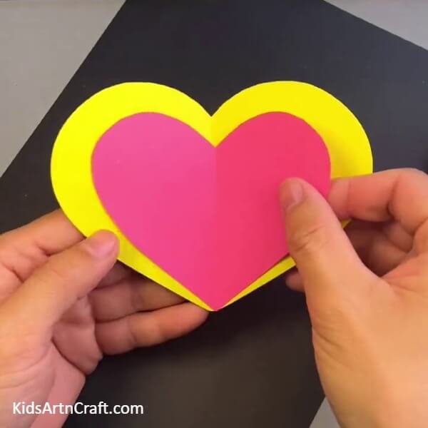 Pasting A Pink Heart Over Yellow - Using a disposable spoon, kids can make a bright butterfly craft.