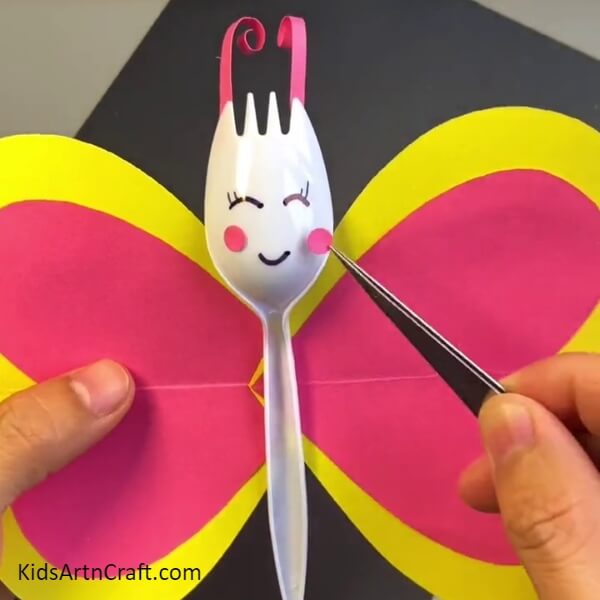 Making Facial Details Of The Butterfly - Kids can use a disposable spoon to make a vivacious butterfly craft.