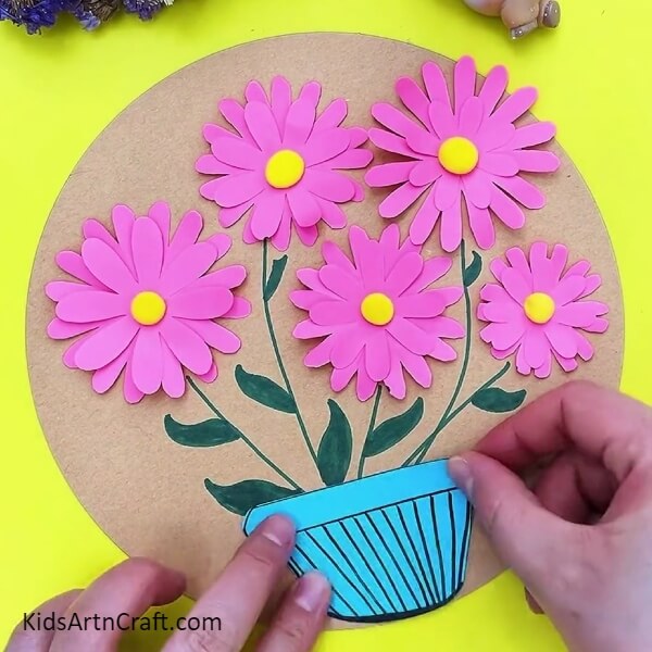 Creating flowerpot with blue paper and pasting it- Teach Kids How to Make 3D Flowers with this Step-by-Step Tutorial