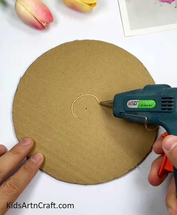 Applying Hot Glue Around The Hole-Assemble a Clock from Cardboard for a Recycled Children's Project 