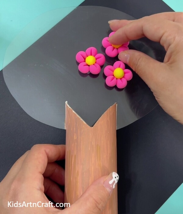 Placing more flowers in the transparent sheet to make blossom tree- Designing a Super-Clay Cherry Blossom Tree From a Toilet Paper Roll 