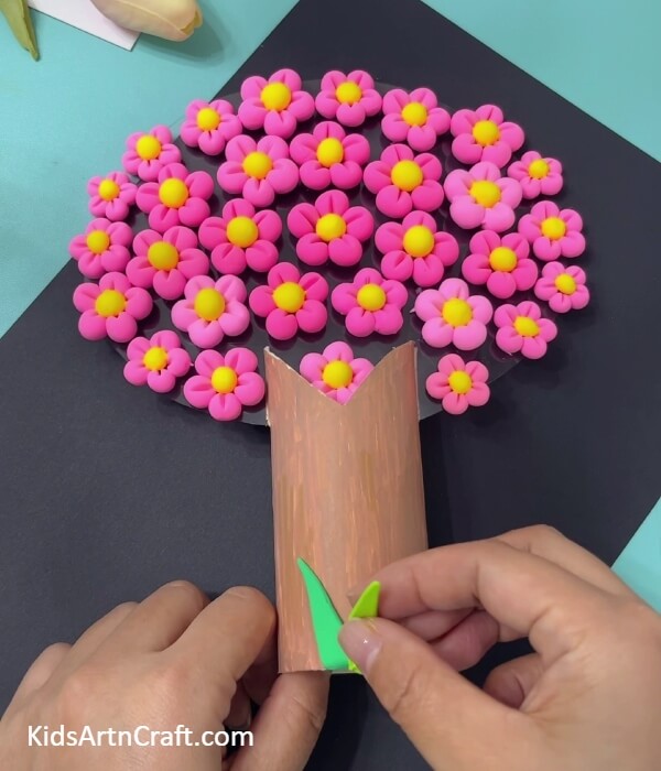 Making grass with dark and light green modeling clay- Form the Super-Clay Cherry Blossom Tree From a Toilet Paper Roll 