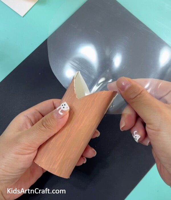 Placing the transparent sheet above the stem- Designing a Super-Clay Cherry Blossom Tree From a Toilet Paper Roll 