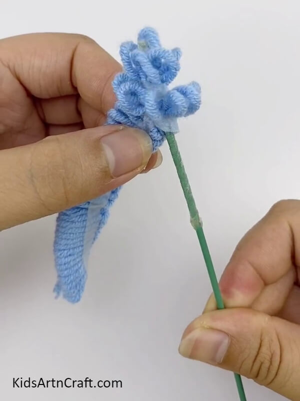 Pull the sides of the Thread while you stick the stem throughout- A Fun and Colorful Craft for Kids with Blue Lavender Threads and Rope Forming 3D Flowers 