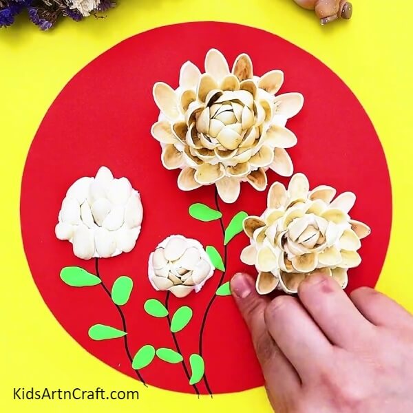 Add Leaves Using Green-colored Clay-An exquisite Peanut Shell and Rose Garden Craft for children.