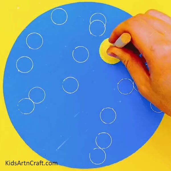 Stamping Yellow Circle And White Bubbles- Creating a splash of color with stamping fish underwater art for children. 