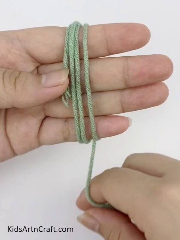 Roll The Yarn Thread On Your Fingers- Step-by-step instructions for making Pom Pom Flowers with vibrant threads - perfect for kids! 