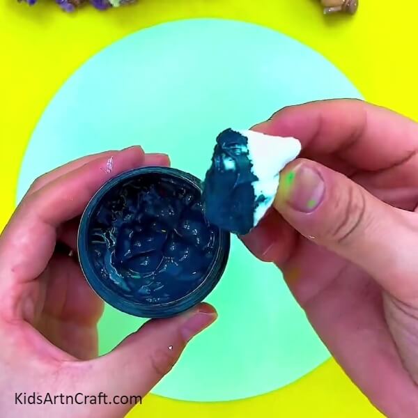 Taking the dip of blue colour into cotton. Creative Forest Painting Art Tutorial For Kids.