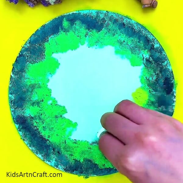 Dabbing the light green colour and merging with other. Procedure for Creative Forest Painting Art Tutorial For Kids.