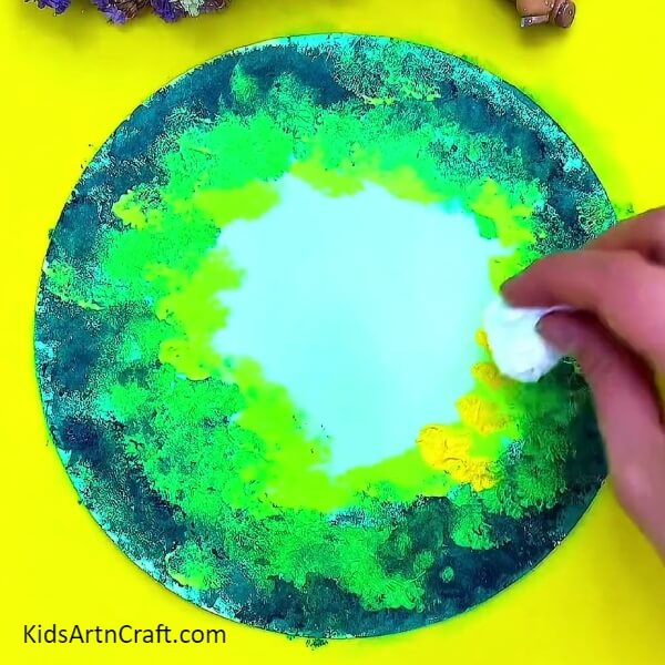 Dabbing the yellow poster colour and merging with other. Step-by-Step procedure for art of forest paintings for beginners.
