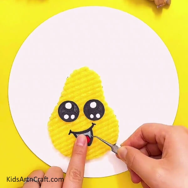 Creating mouth for pear- Learn how to make a delightful Foam Pear craft with the help of this kid-friendly tutorial.